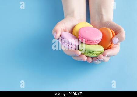 Girl holding colorful French macarons in hands Stock Photo