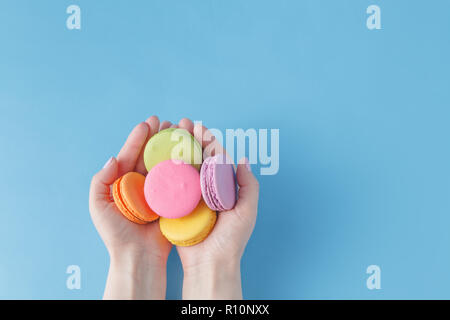 Girl holding colorful French macarons in hands Stock Photo