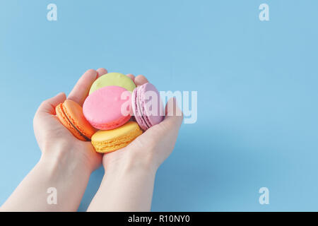 Girl holding colorful French macarons in hands Stock Photo