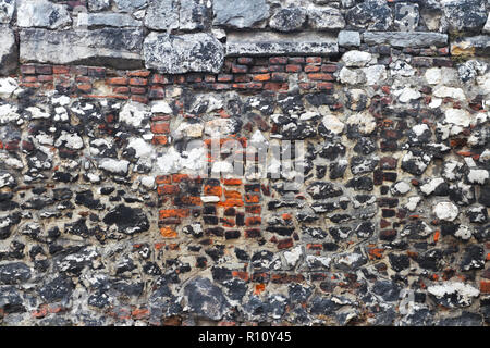 Old rugged stone and brick wall as a background. Stock Photo