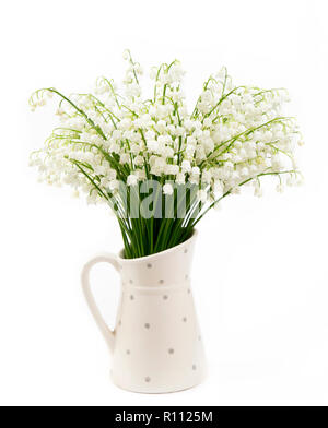 Bouquet of white flowers Lily of the valley (Convallaria majalis) also called: May bells, Our Lady's tears and Mary's tears in a white dotted jug shap Stock Photo