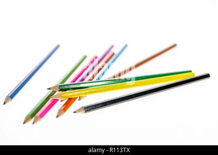Coloured pencils randomly arranged on a white background. Colored pencil crayons.  Pencils are sharpened ready for drawing or sketching. Stock Photo