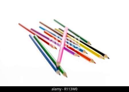 Coloured pencils randomly arranged on a white background. Colored pencil crayons.  Pencils are sharpened ready for drawing or sketching. Stock Photo