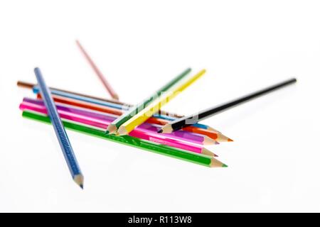 Coloured pencils randomly arranged on a white background. Colored pencil crayons.  Pencils are sharpened ready for drawing or sketching. Stock Photo