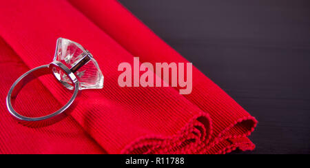 Big diamond ring on the red table napkin on the wooden table Stock Photo