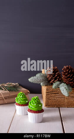 Bright red cupcakes in the form of Christmas trees on a white wooden background Stock Photo