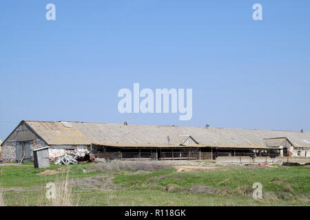 Old farm building. Leaky slate roof on the farm. The consequences of hail. Stock Photo