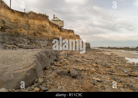 House on edge of cliff washed away by the sea, coastal erosion, global warming, rising sea levels, Happisburgh Norfolk, UK Stock Photo