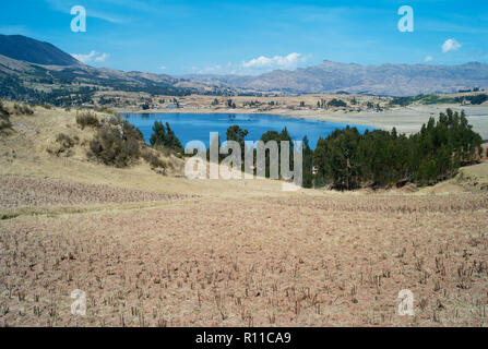 Mesmerizing Dark Blue Lake Surrounded by Dry Golden Grass Fields in the Peruvian Andes near Chinchero, Peru Stock Photo
