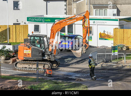 MOUNTAIN ASH, WOUTH WALES - OCTOBER 2018: Tracked excavator driving along an unfinished road on the site of a new housing development in Mountain Ash  Stock Photo