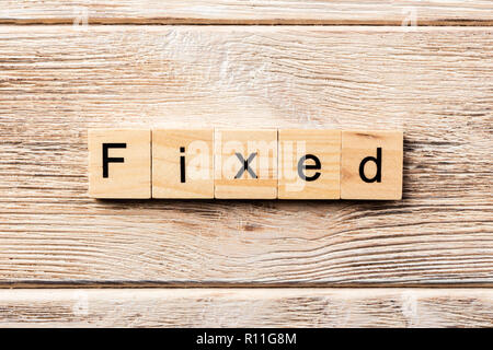 fixed word written on wood block. fixed text on table, concept. Stock Photo