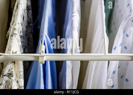 Different types of clothes left hanging to dry on a clotheshorse Stock Photo