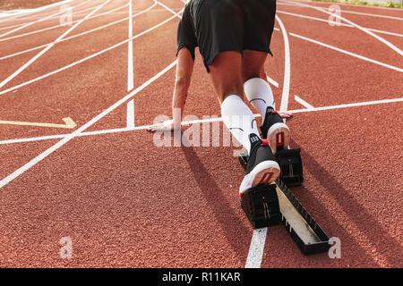 Cropped photo of handsome strong young sportsman running outdoors ready to run. Stock Photo