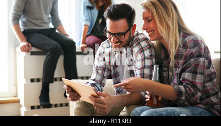 Cheerful couple using digital tablet and smiling Stock Photo