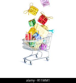 Multicolored gift boxes with beautiful golden bows fall into a gift-filled shopping cart isolated on a white background Stock Photo