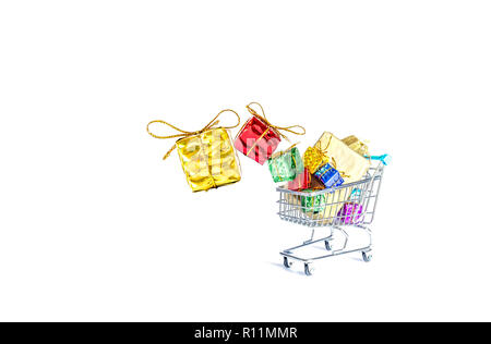 Multicolored gift boxes with beautiful golden bows fall into a gift-filled shopping cart isolated on a white background Stock Photo