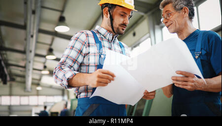 Team Of Engineers Having Discussion In Factory Stock Photo