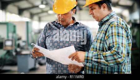 Team Of Engineers Having Discussion In Factory Stock Photo