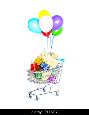 Shopping cart with colorful helium balloons, overflowing with boxes of gifts in multi-colored packaging with beautiful golden bows close-up isolated o Stock Photo