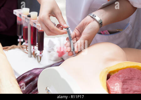 A student learning how to give an intramuscular injection Stock Photo