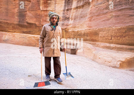 A Jordanian worker with a broom and shovel in Petra a historical and archeological city in South Jordan. Stock Photo