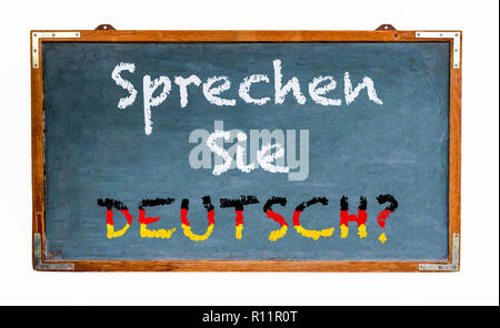 “Sprechen Sie Deutsch?” (in German language, Do you speak German?) written on a wide blue old grungy vintage wooden chalkboard or retro blackboard wit Stock Photo