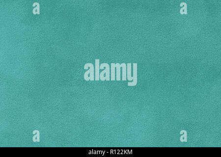 turquoise matte background of suede fabric, closeup. Velvet texture of seamless cyan leather. Felt materisl macro. Stock Photo
