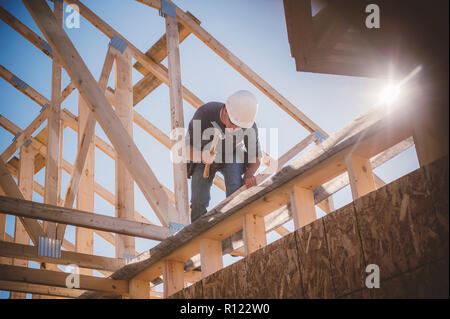 Builder working on rooftop frame of building Stock Photo