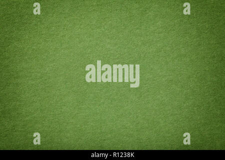 Light green matte background of suede fabric, closeup. Velvet texture of seamless olive leather with vignette. Felt materisl macro. Stock Photo