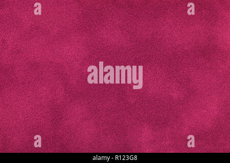 Dark purple matte background of suede fabric, closeup. Velvet texture of seamless wine leather. Felt materisl macro. Stock Photo