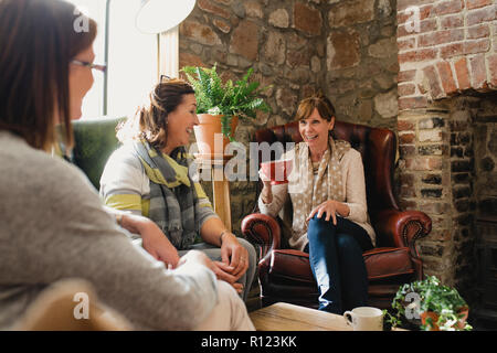 Small group of mature female friends sitting in a small coffee shop enjoying a catch up and a coffee. Stock Photo