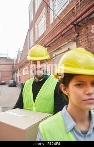 Two workers of a forwarding agency as a delivery service in front of a factory or a depot Stock Photo