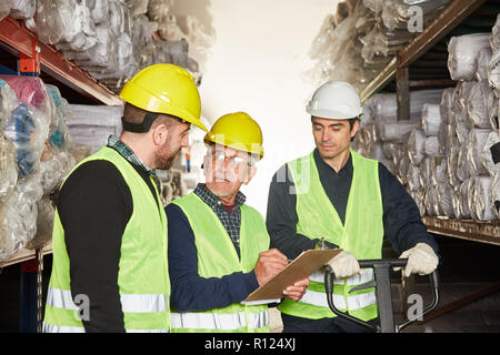 Order picker with checklist and clipboard and warehouse worker in shipping Stock Photo