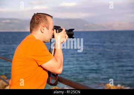Photographer on beach, summer time. / Guys tourist in nature taking photos Adriatic Sea, Mediterranean, natural environment, enjoying beautiful summer Stock Photo