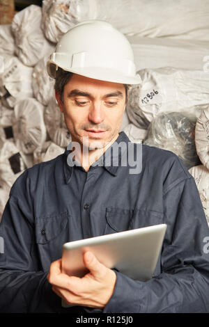 Warehouse worker using tablet computer checks inventory during inventory Stock Photo