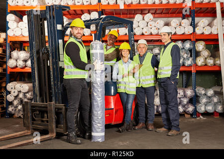 Successful logistics team with forklift in warehouse in shipping center Stock Photo