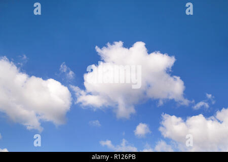 The clear blue sky with white clouds, closeup / Very fine weather with stratocumulus and cumulus clouds on a summer day / Cloudy background wallpaper, Stock Photo