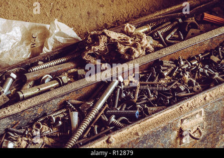 Box full of old screws and nuts in different conditions and sizes. Stock Photo