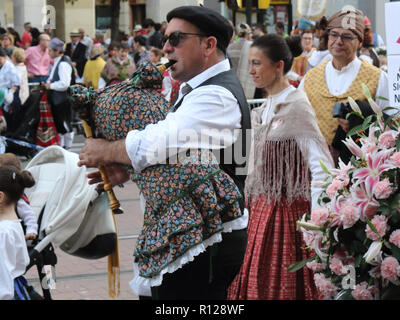 Countrymen dressed in Spanish folkloristic dresses and playing the bagpipe during a reenactment parade (Ofrenda de flores) in Pilares 2018 festival Stock Photo