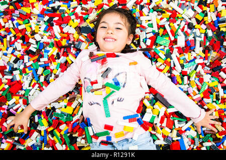 Little girl with educational toy blocks. Children play at day care or preschool. Mess in kids room. View from above. Stock Photo
