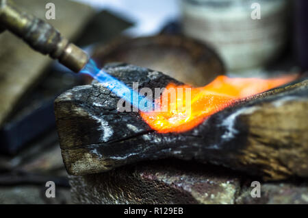 Close-up of jewelry welding with blowtorch. Goldsmith's workshop. Stock Photo