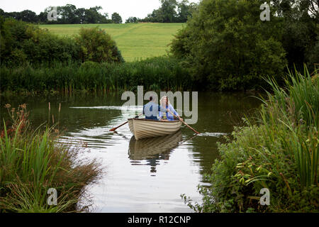 Mature couple in rowing boat on rural lake Stock Photo