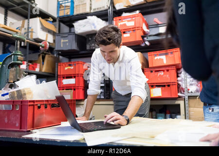 Man using laptop in demonstration in warehouse Stock Photo
