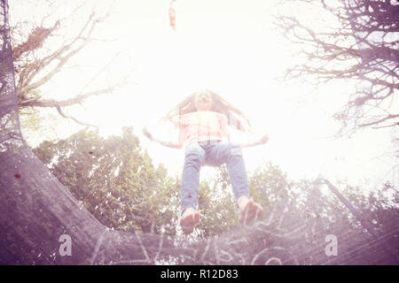 Girl jumping on trampoline, low angle view Stock Photo