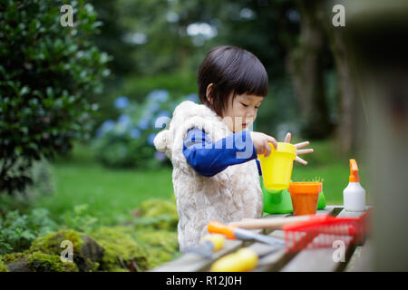 toddler baby girl  pretend play in garden Stock Photo