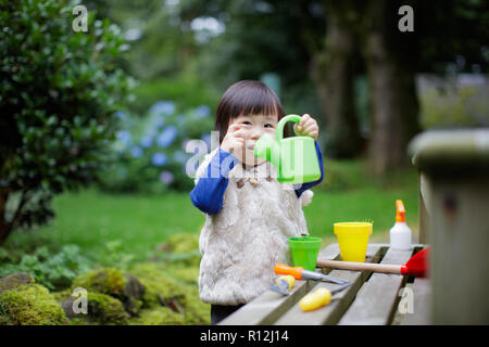 toddler baby girl  pretend play in garden Stock Photo