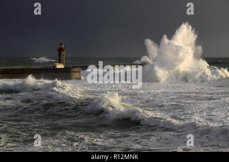April in Portugal; Storm waves over beacon and lighthouse of the harbor of river Douro, Porto,  Portugal. Late evening light (low edition photo) Stock Photo