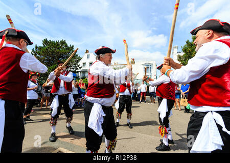 Broadstairs Folk week festival. Victory Morris men side, dressed as 18th century sailors, dancing on seafront promenade. Stock Photo