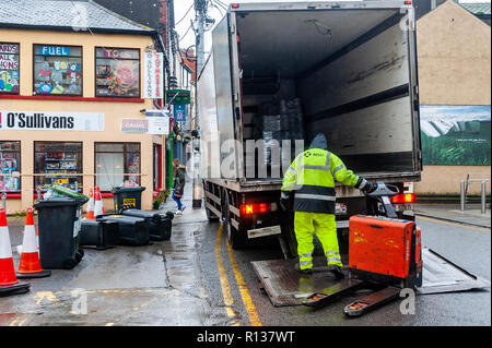 Skibbereen, West Cork, Ireland. 9th Nov, 2018. A delivery man passes wheelie bins blown over by the high winds in Skibbereen.  This afternoon will see a continuation of strong winds, which will reach gale force on the coasts. Highs today of 9 to 13°C. Credit: Andy Gibson/Alamy Live News. Stock Photo