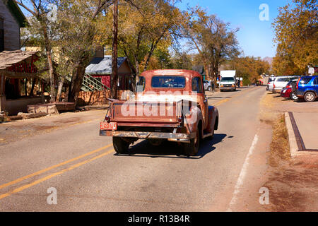 Old 1960s Chevy pickup truck driving down highway NM-14 in Madrid, New Mexico Stock Photo